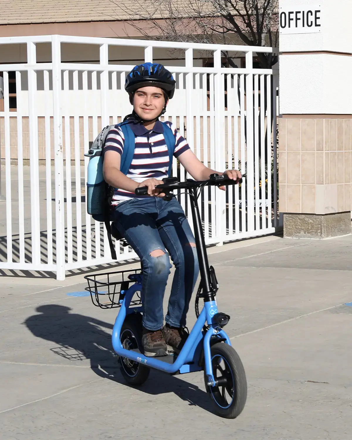 boy commuting to school on a seated electric scooter