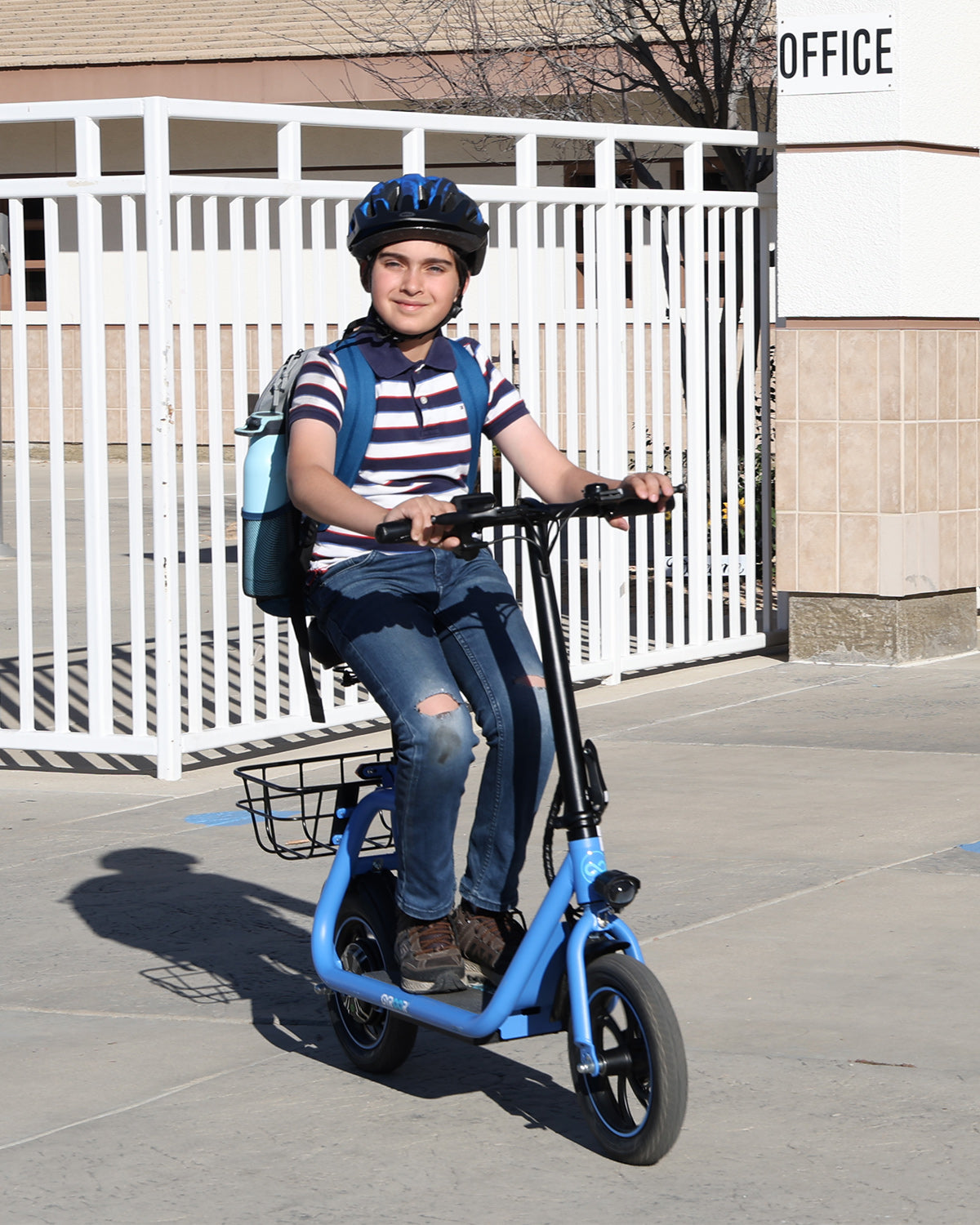 boy commuting to school on a seated electric scooter