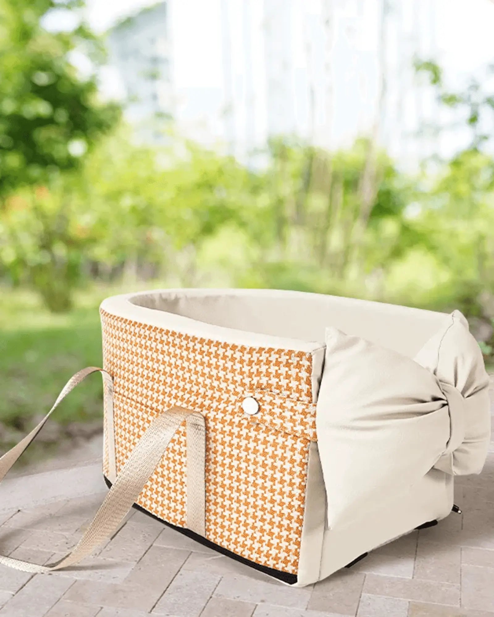 Orange and white houndstooth padded pet basket insert with beige straps and button, designed for outdoor use on patio or garden