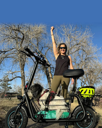 woman using seated electric scooter while walking dog in park